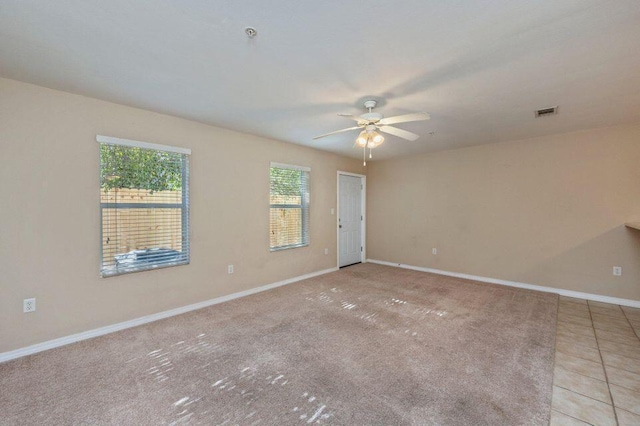 spare room with ceiling fan and light carpet