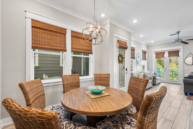 dining room with ceiling fan with notable chandelier and ornamental molding