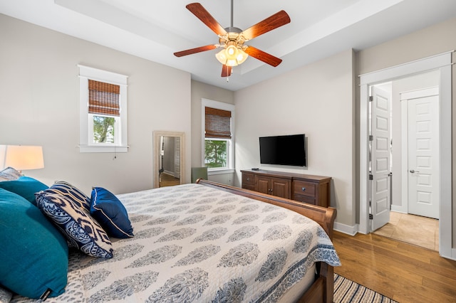 bedroom featuring multiple windows, ceiling fan, and hardwood / wood-style flooring