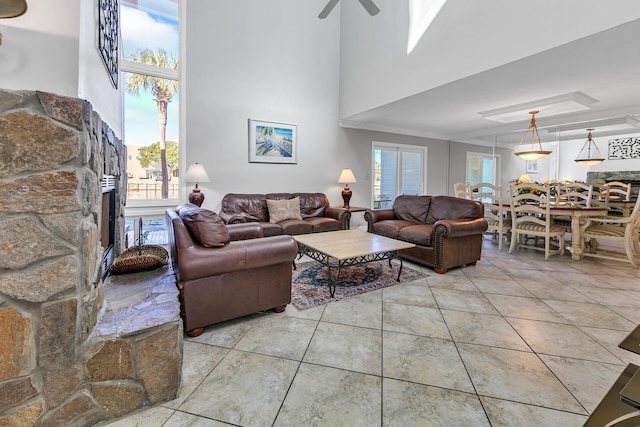 900 Gulf Shore Dr Unit 03, Destin, FL 32541 - living room featuring a fireplace, ceiling fan, tile patterned flooring, and a high ceiling