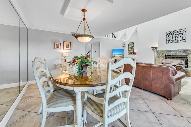 900 Gulf Shore Dr Unit 03, Destin, FL 32541 - dining space with a stone fireplace, light tile patterned floors, and crown molding