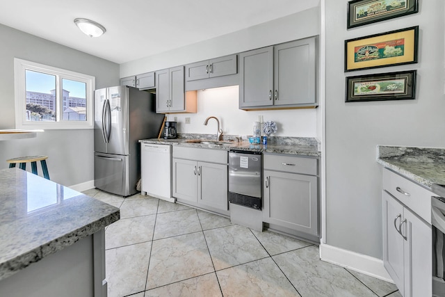 900 Gulf Shore Dr Unit 03, Destin, FL 32541 - kitchen with white dishwasher, a sink, gray cabinetry, freestanding refrigerator, and light stone countertops