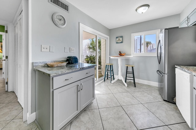 900 Gulf Shore Dr Unit 03, Destin, FL 32541 - kitchen with freestanding refrigerator, light stone counters, baseboards, and dishwasher