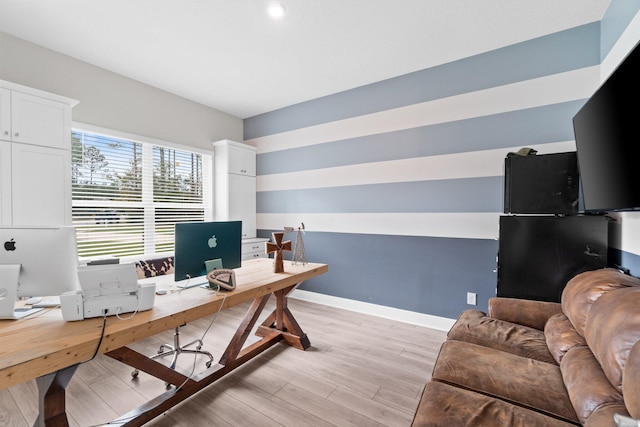 home office with light hardwood / wood-style flooring