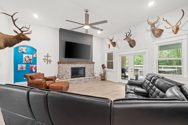 living room with a fireplace, ceiling fan, hardwood / wood-style floors, and french doors