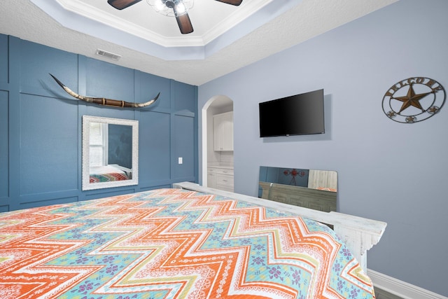 bedroom featuring a raised ceiling, ceiling fan, and crown molding