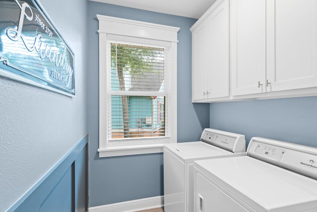 clothes washing area featuring cabinets and washer and dryer