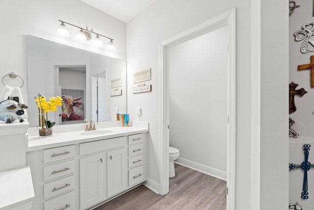 bathroom with vanity, hardwood / wood-style flooring, and toilet