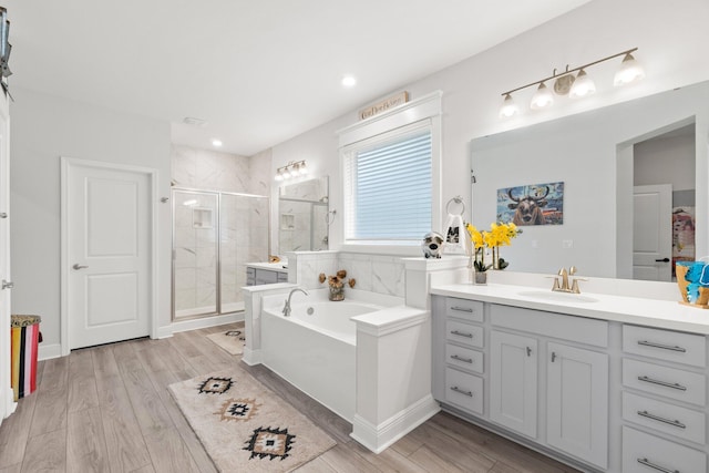 bathroom with independent shower and bath, vanity, and wood-type flooring