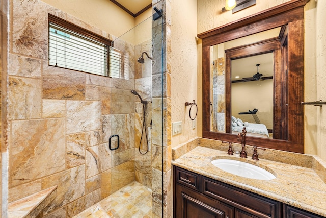 ensuite bathroom with vanity, a stall shower, ceiling fan, a textured wall, and connected bathroom