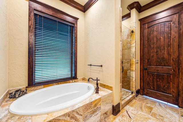 bathroom featuring a garden tub, a textured wall, a stall shower, and ornamental molding