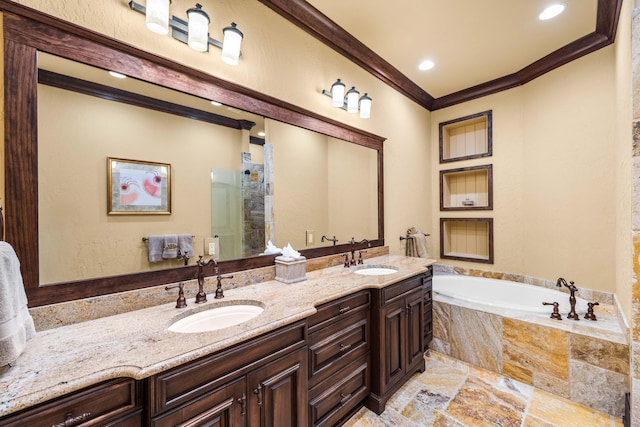 bathroom with ornamental molding, a stall shower, a garden tub, and a sink