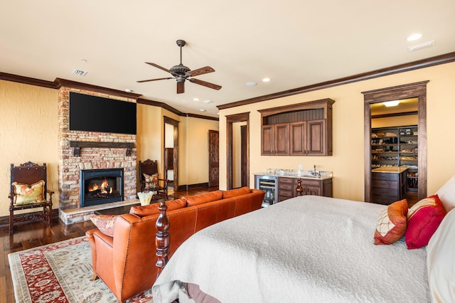 bedroom featuring dark wood finished floors, a stone fireplace, beverage cooler, and ornamental molding