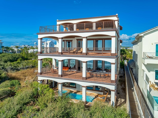 back of property with a balcony and a patio area