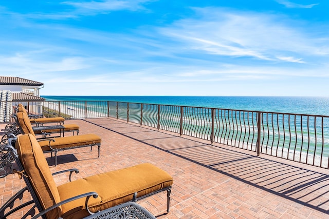 view of patio featuring a view of the beach and a water view