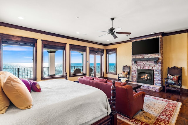 bedroom featuring access to outside, wood finished floors, recessed lighting, a stone fireplace, and crown molding