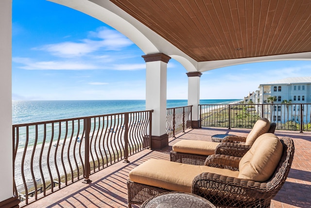 balcony featuring a view of the beach and a water view