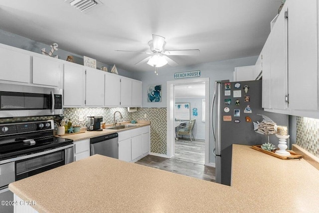 kitchen featuring sink, white cabinets, light hardwood / wood-style floors, and appliances with stainless steel finishes