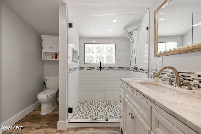 bathroom with wood-type flooring, vanity, toilet, and walk in shower