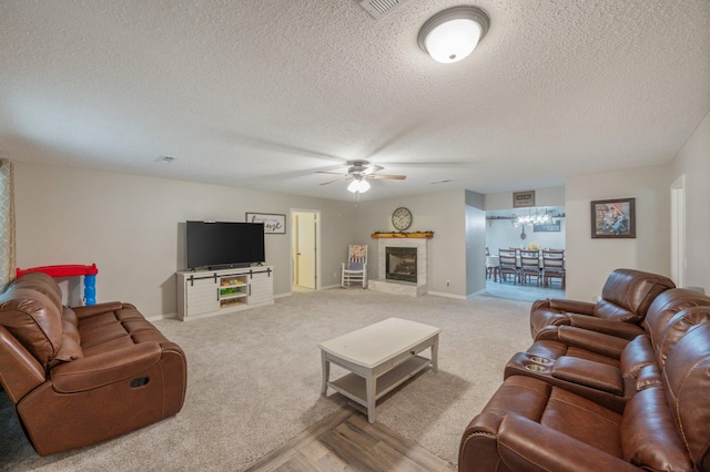 living room with ceiling fan, carpet, and a textured ceiling