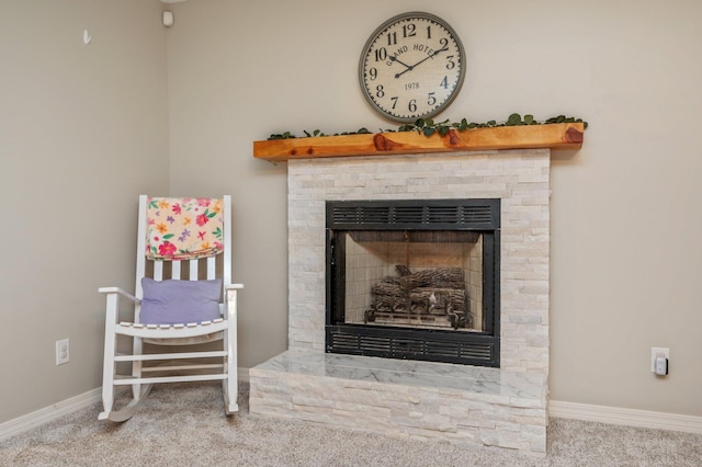 room details featuring a stone fireplace and carpet floors