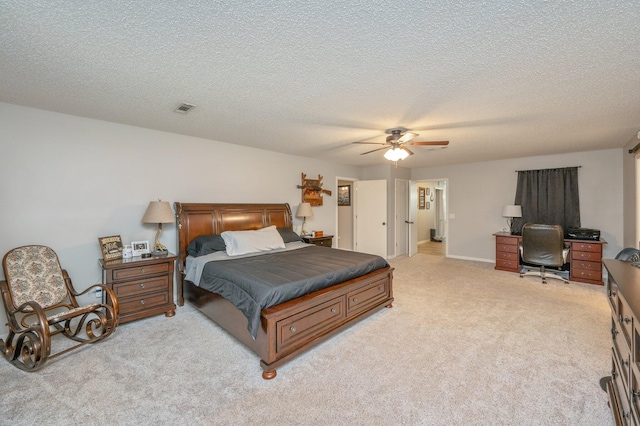 bedroom featuring ceiling fan, light colored carpet, and a textured ceiling