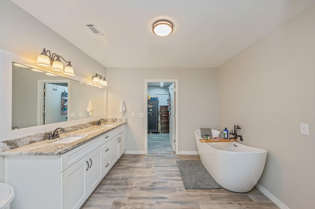 bathroom featuring a bathing tub, hardwood / wood-style floors, and vanity