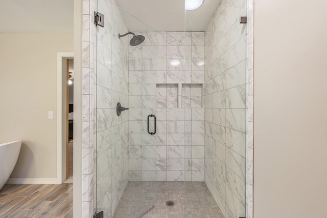 bathroom featuring hardwood / wood-style floors and a shower with door