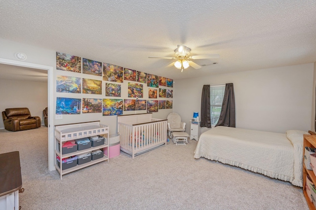 carpeted bedroom with ceiling fan and a textured ceiling