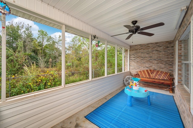 unfurnished sunroom featuring ceiling fan