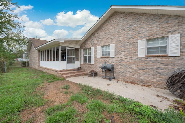 back of house featuring a yard and a sunroom