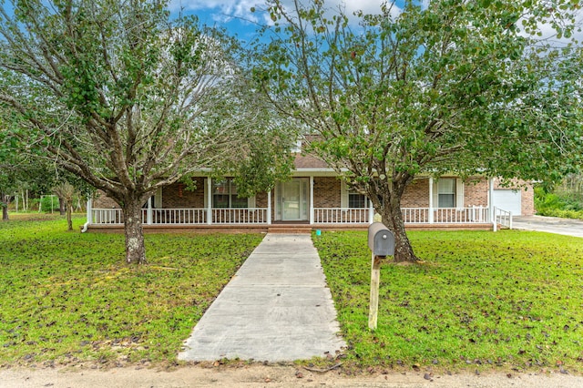 view of property hidden behind natural elements featuring a porch, a garage, and a front lawn