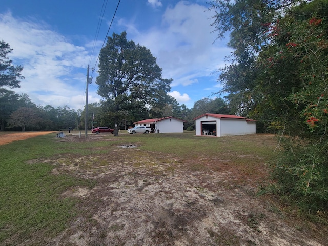 view of yard featuring a garage and an outbuilding