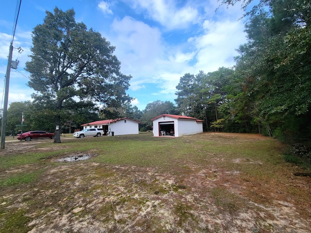 114 W May Lilly Ct, Defuniak Springs, FL 32433 - view of green lawn with an outdoor structure and a garage