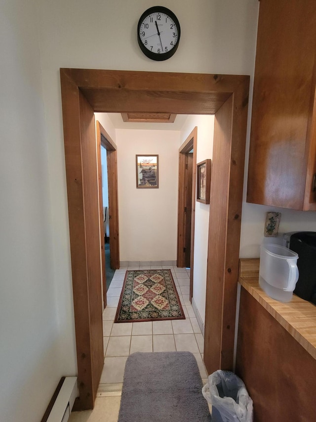 corridor featuring light tile patterned floors and a baseboard heating unit