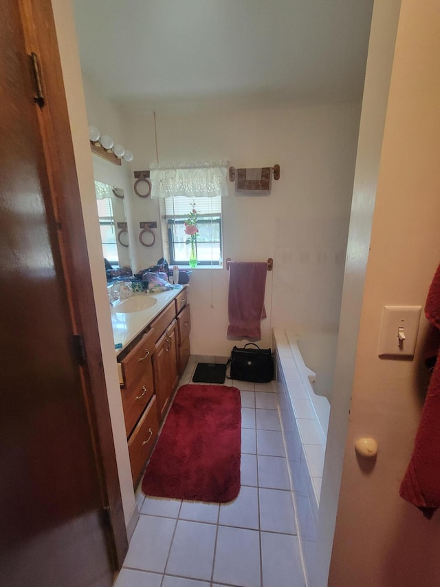 bathroom with tile patterned flooring, vanity, and a bath