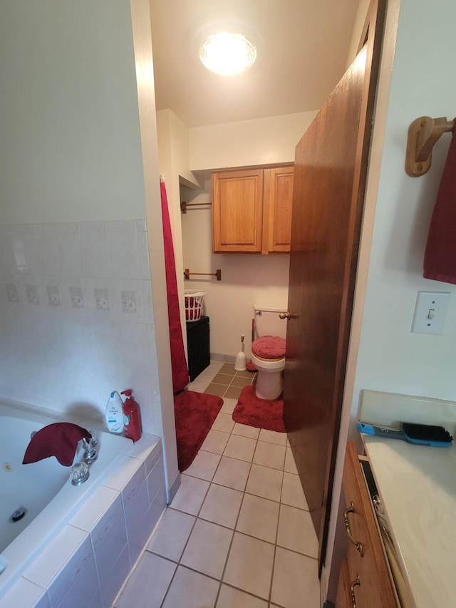 bathroom featuring vanity, tile patterned floors, toilet, and a relaxing tiled tub