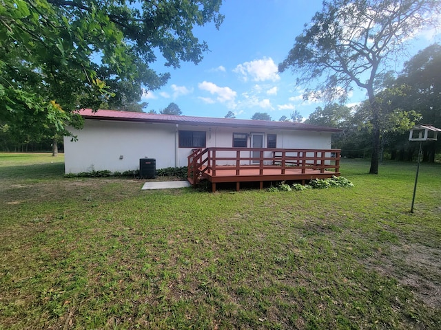 114 W May Lilly Ct, Defuniak Springs, FL 32433 - back of house featuring a deck, central AC, a yard, stucco siding, and metal roof