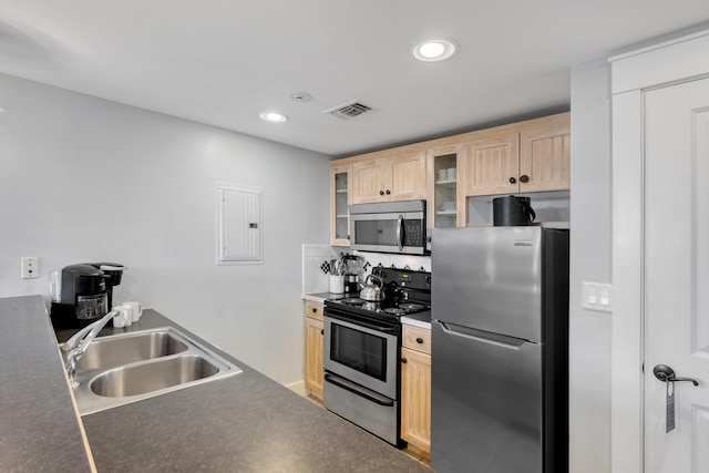 kitchen with light brown cabinets, electric panel, sink, appliances with stainless steel finishes, and concrete floors