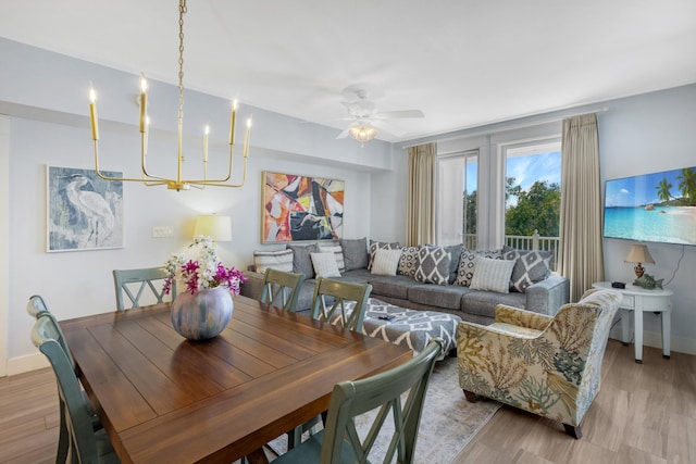 dining area featuring ceiling fan with notable chandelier and light hardwood / wood-style floors