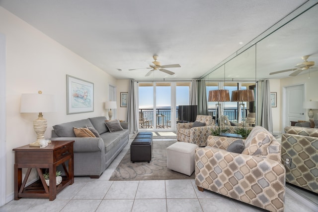 living room featuring light tile patterned floors, expansive windows, and ceiling fan