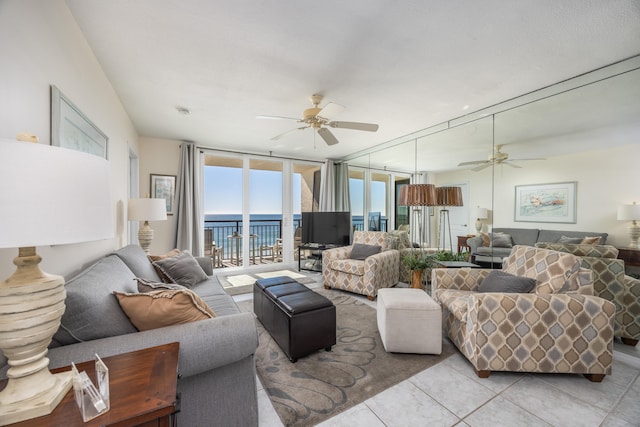 tiled living room with expansive windows and ceiling fan