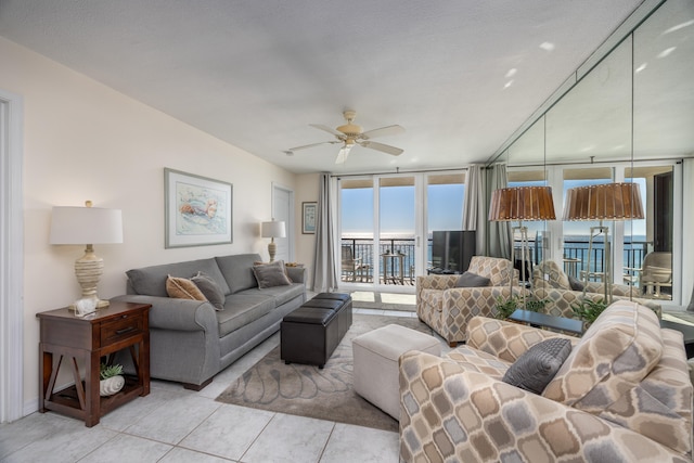 tiled living room featuring ceiling fan and a wall of windows