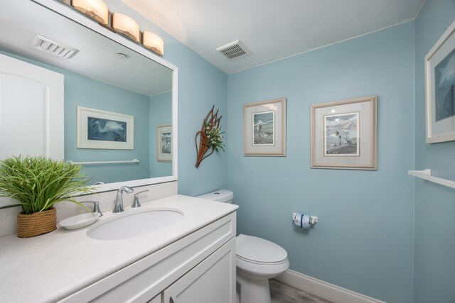 bathroom featuring hardwood / wood-style flooring, vanity, and toilet