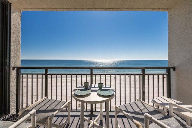 balcony with a water view and a beach view