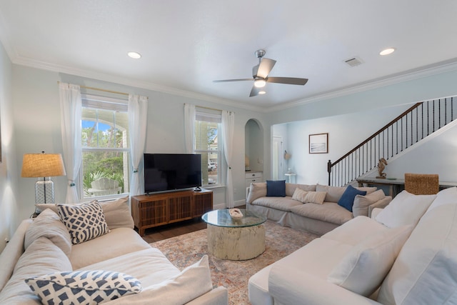 living room with wood-type flooring, ceiling fan, and crown molding