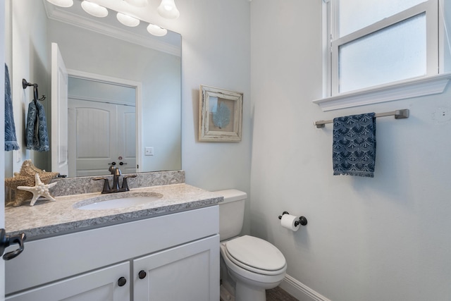 bathroom featuring vanity, toilet, and ornamental molding