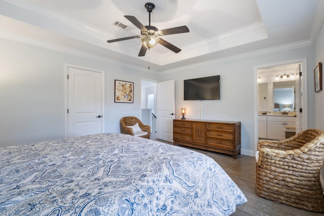 bedroom with ensuite bath, ornamental molding, a raised ceiling, ceiling fan, and dark hardwood / wood-style floors