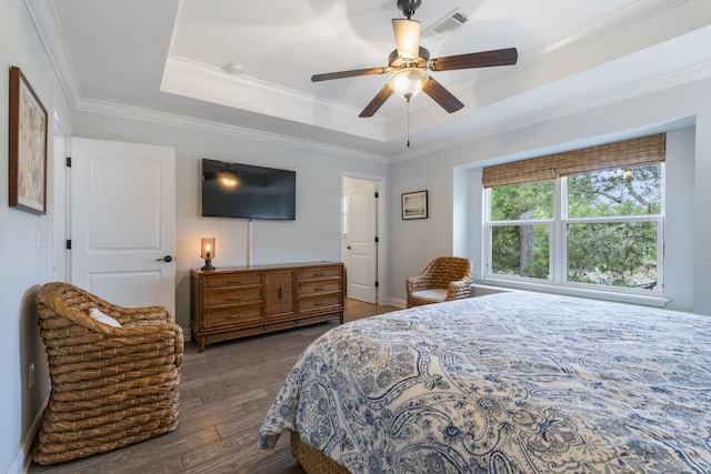 bedroom featuring a raised ceiling, ceiling fan, dark hardwood / wood-style floors, and ornamental molding