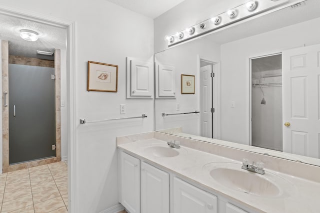 bathroom featuring tile patterned floors, vanity, and a textured ceiling